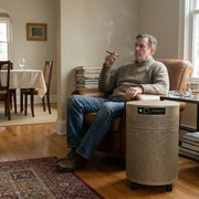 Man smoking a cigar in a sitting room with an Airpura T700 DLX air purifier