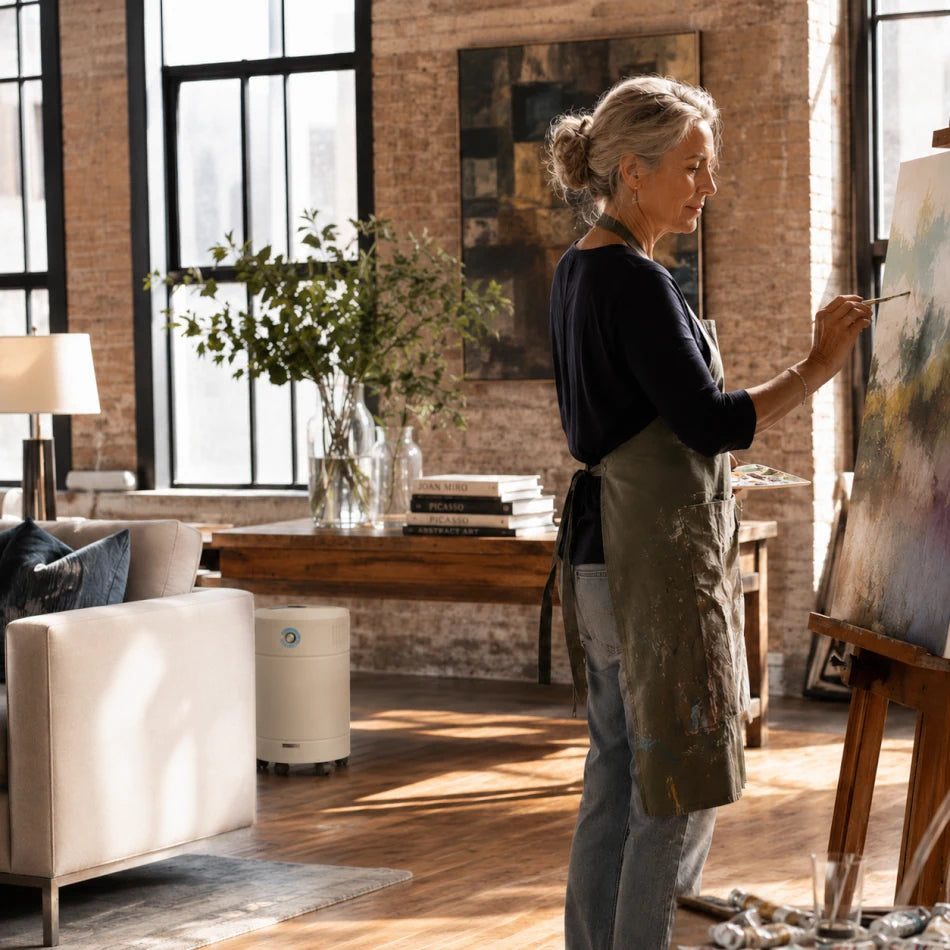 woman painting on canvas in an art studio with allerair airmedic pro 6 hd air purifier